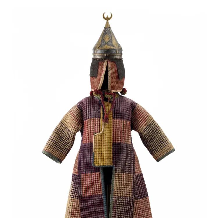 A patterned fabric coat with a conical helmet with a crescent fixed on top