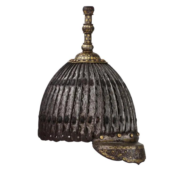 A metal helmet ornamented with a gilded brim and blunt point to the bowl
