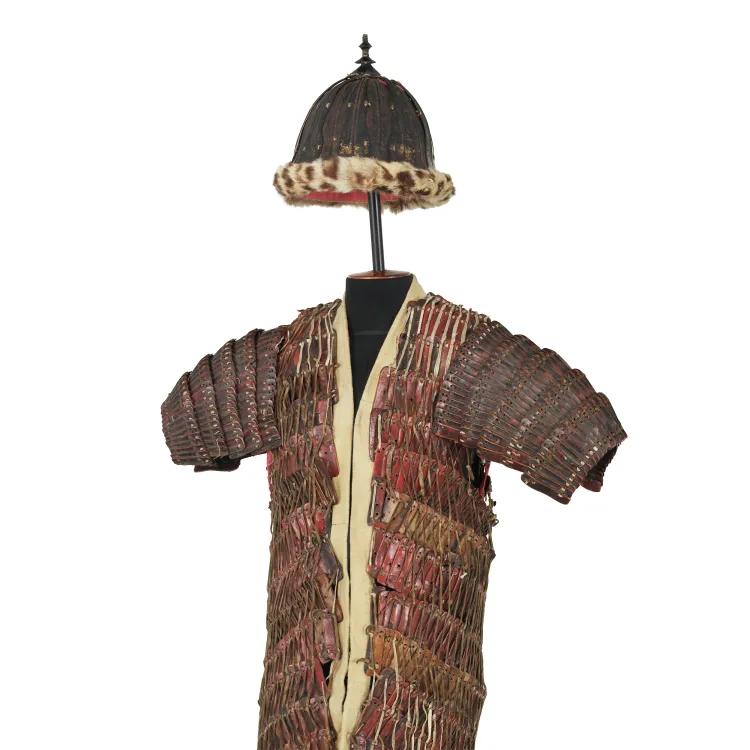 A reddish-brown coat of small strips of leather or metal sown together with a fur-lined hemispherical helmet