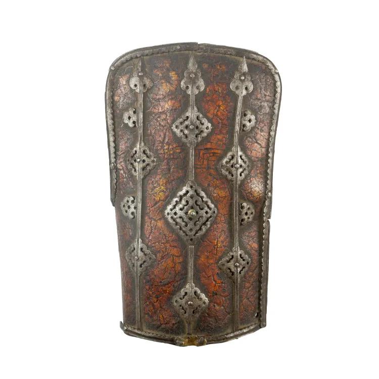 A leather bracer in brown, banded by decorative metal ribs